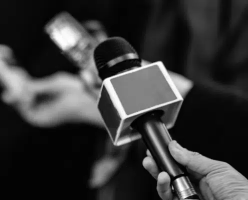 black and white image of hand holding microphone