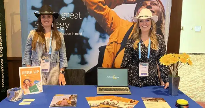 2 women standing at booth at trade conference